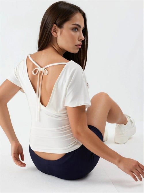 Blusa con cuello en v y detalle de lazo busem - Kiabi Blusa con cuello en v y detalle de lazo busem - Kiabi