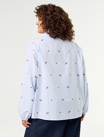 Blusa con flores bordadas y cuello alto