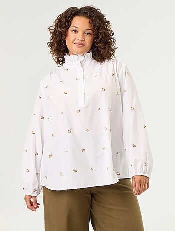 Blusa con flores bordadas y cuello alto