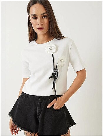 Camiseta con accesorio floral y emblema lucci