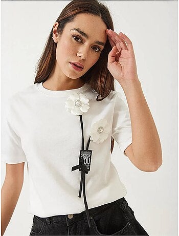 Camiseta con accesorio floral y emblema lucci