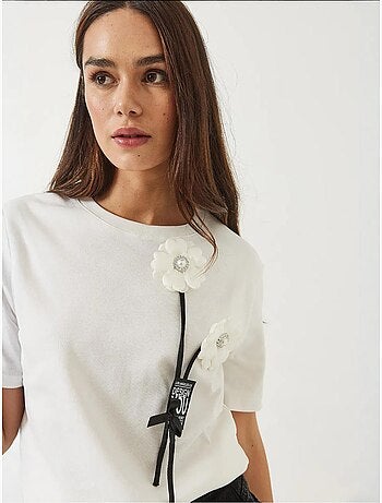 Camiseta con accesorio floral y emblema lucci