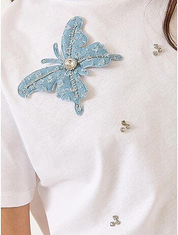 Camiseta de manga corta con accesorios de mariposa y adornos de piedras lucci