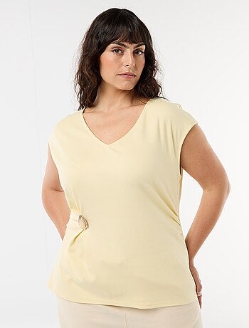 Camiseta drapeada con joya dorada