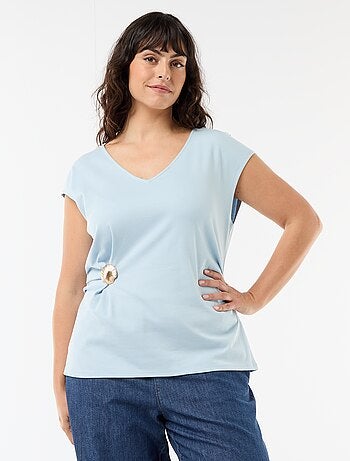 Camiseta drapeada con joya dorada