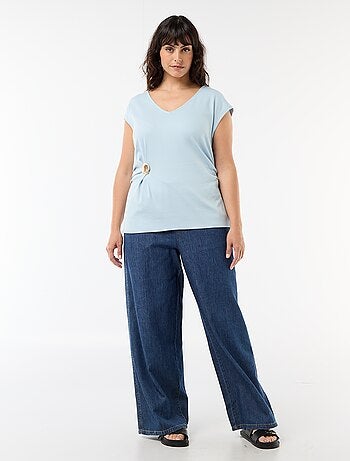 Camiseta drapeada con joya dorada