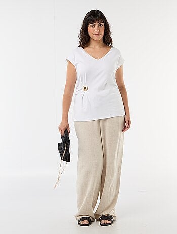 Camiseta drapeada con joya dorada