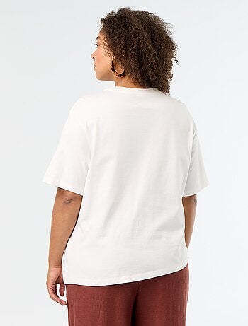 Camiseta drapeada con joya dorada tipo broche