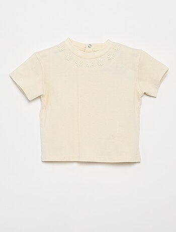 Camiseta lisa con flores de fantasía en el cuello