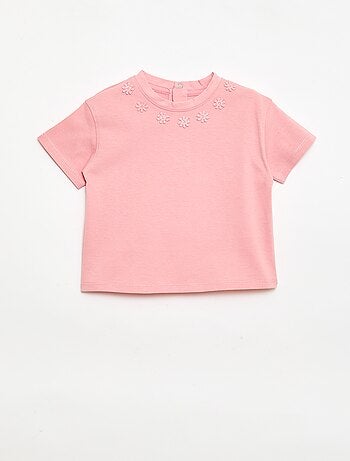 Camiseta lisa con flores de fantasía en el cuello