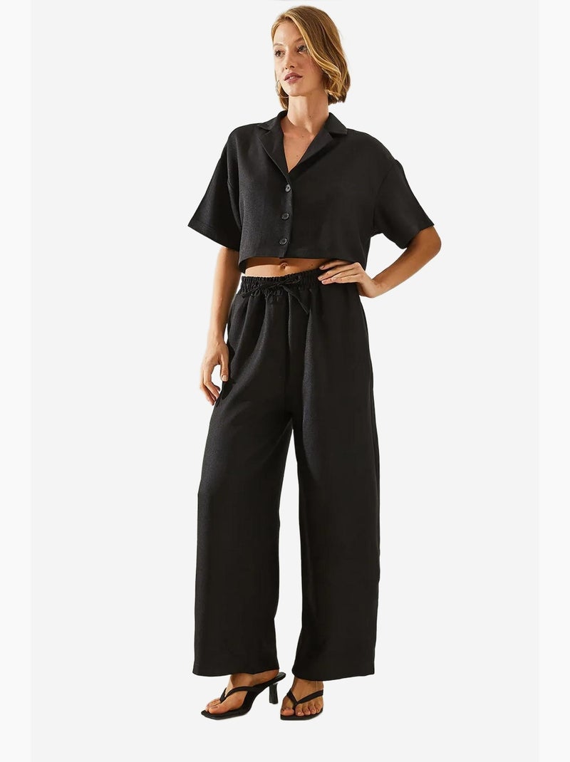 Conjunto de dos piezas con top corto, pantalón abotonado y bolsillos lucci Negro - Kiabi