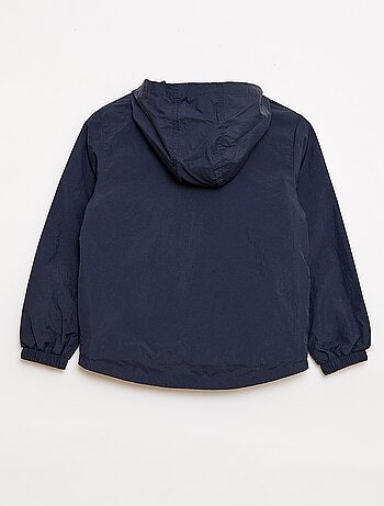 Cortavientos liso que se guarda en su capucha