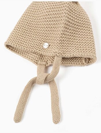 Gorro de punto con pompones y tirantes laterales