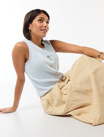 Top sin mangas con botones dorados