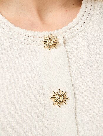 Top sin mangas con botones dorados